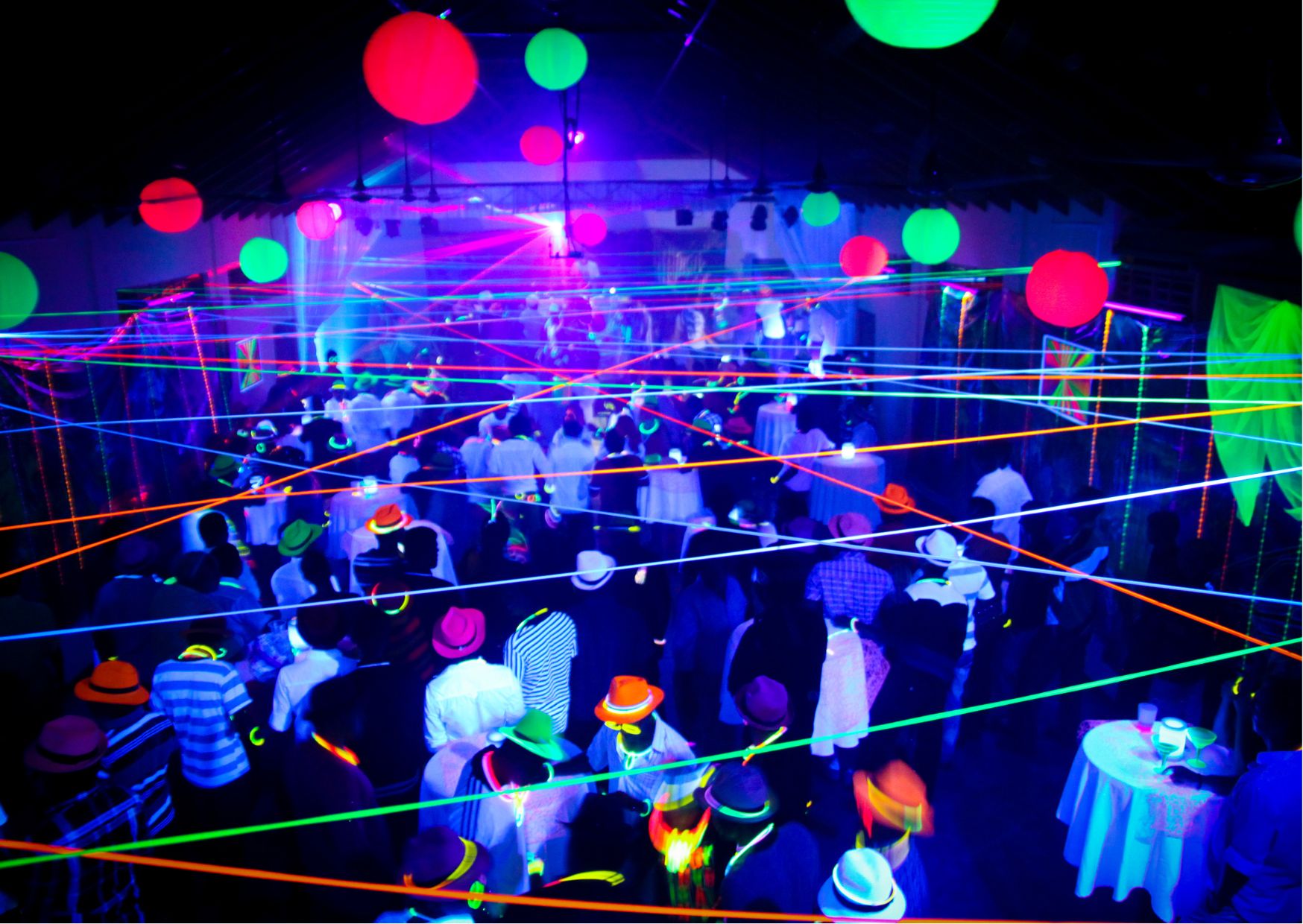 Blacklight party with glowing neon strings, UV clothing, and vibrant illuminated spheres.