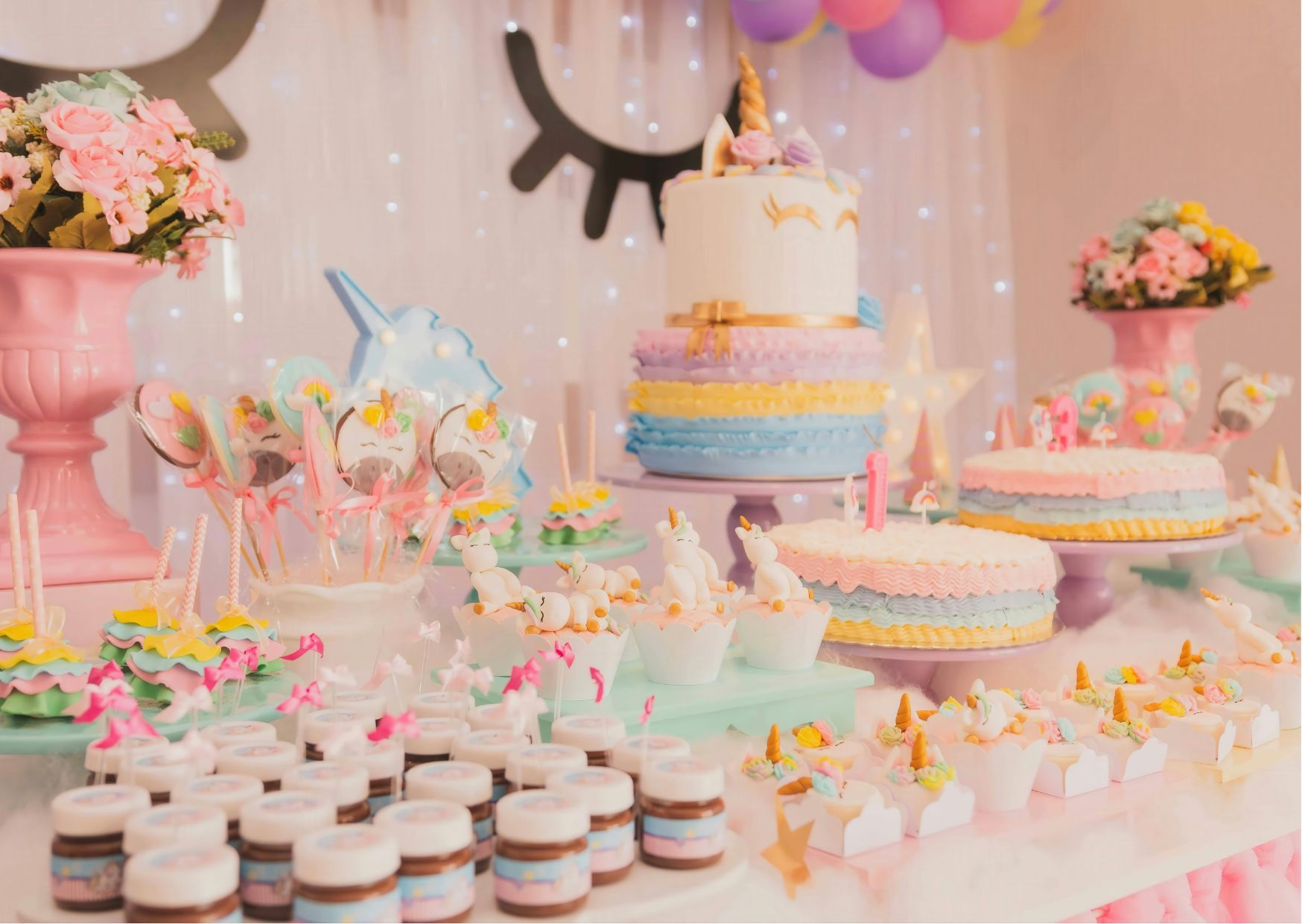 Pastel cakes, unicorn cupcakes, and colorful balloons with whimsical fantasy decor.