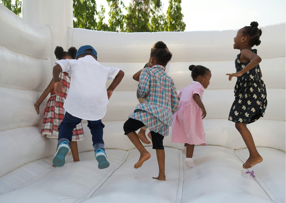 Children playing on white inflatable bouncy castle, active entertainment for wedding reception guests