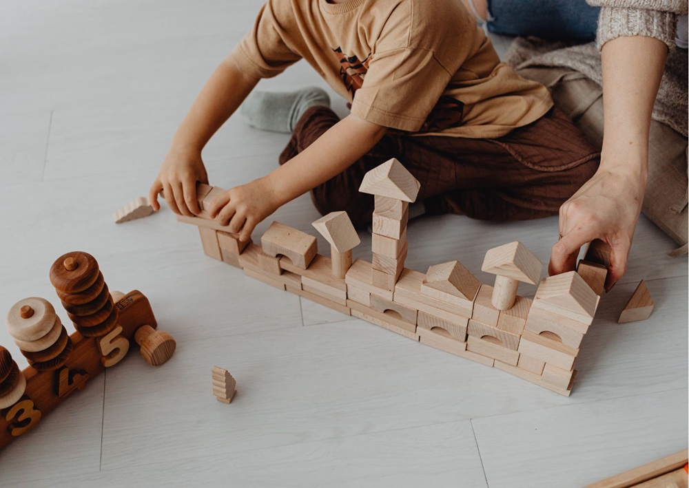 Adult and child building with wooden blocks, calm entertainment option for wedding reception