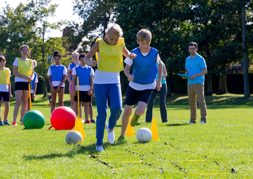 Children race through cones and balls during a fast-paced outdoor sports activity.